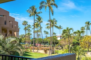 Un hotel de diseño moderno, con un jardín bien cuidado con palmeras y una vista despejada del océano.