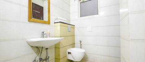A small bathroom with a sink, toilet, and a mirror.
