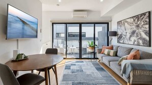 Ein modernes Wohnzimmer mit einer Couch, einem Couchtisch und einem Fernseher.