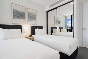 A hotel room with two beds, a large mirror, and artwork on the wall. - Spacious 2-Bed Apartment with Rooftop Views (North Fremantle)