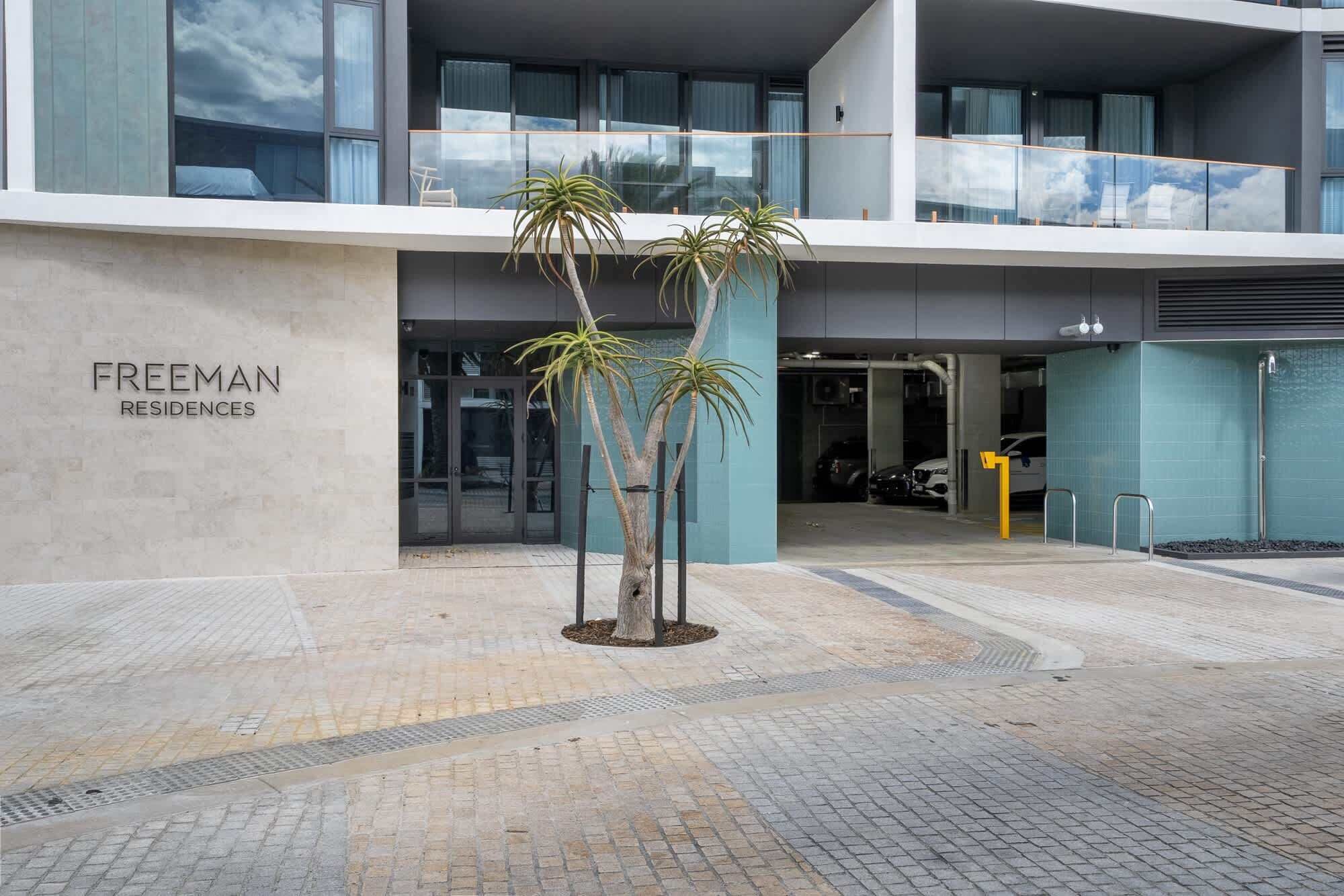 A modern building with a sign reading "FREEMAN RESIDENCES".