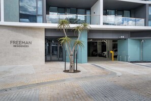 A modern building with a sign reading "FREEMAN RESIDENCES". - Trendy 1-Bed Retreat in Fremantle with Rooftop (North Fremantle)