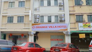 Un edificio de varios pisos con un letrero destacado del Hotel Orange Villa.