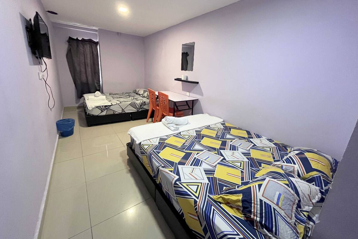 Een kleine, praktische kamer met een bed, bureau en stoel.