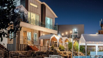 Un edificio de varios pisos con balcón, zona de estar al aire libre y piscina.