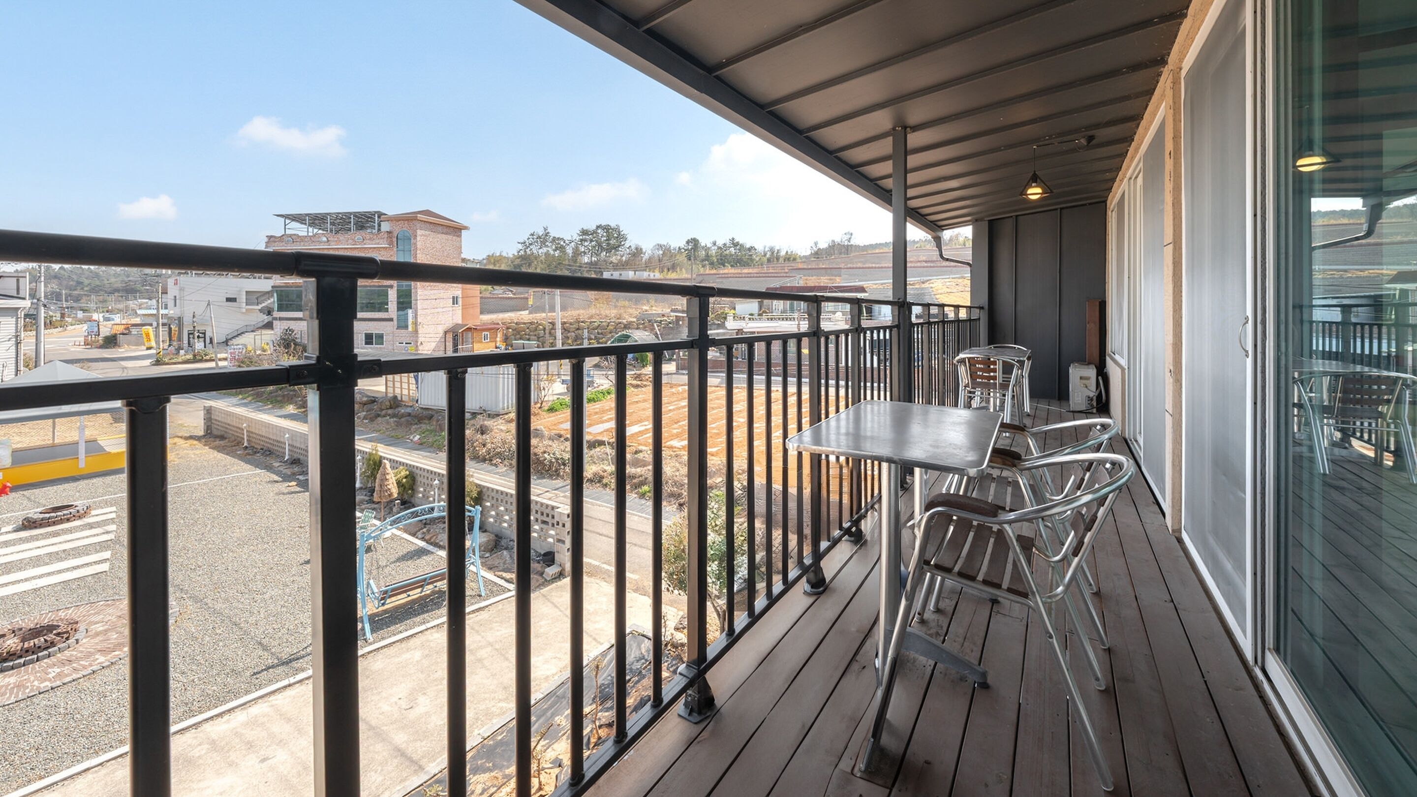 En balkon med et bord og stole, der kigger ud over en byggeplads.