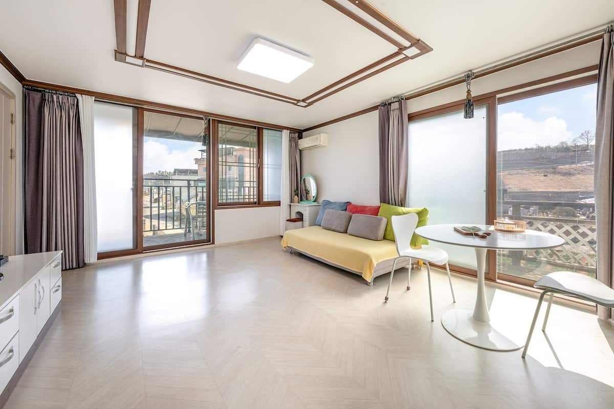 Ein großzügiger Wohnbereich mit einer Couch, einem Esstisch und einem Balkon mit Blick.