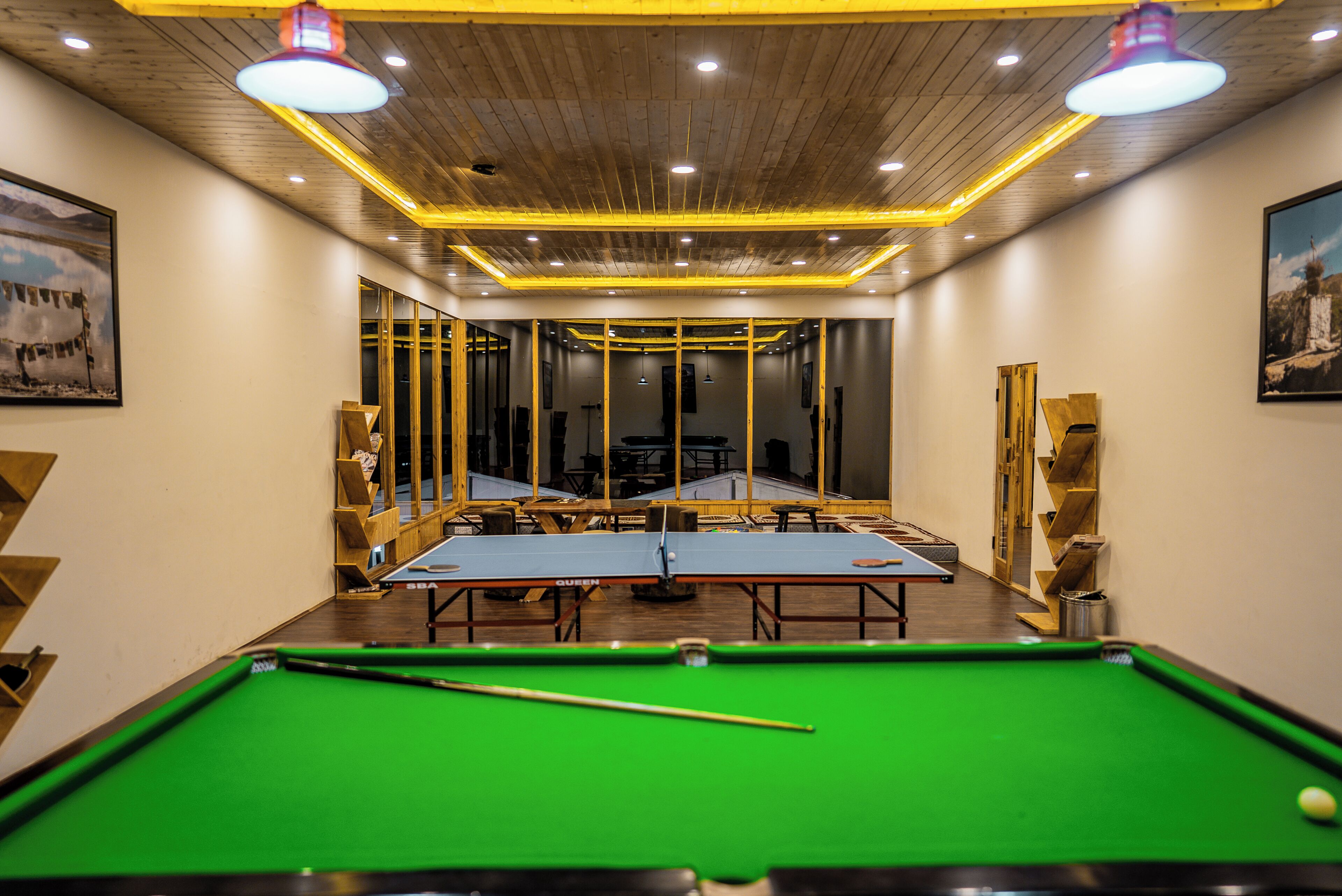 A pool table with a cue stick, a green felt table, and a billiard ball.