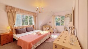A bedroom with a large bed, a chair, a table with glasses, and a chandelier. - Secluded 5rooms Farmhouse – Spacious Garden, BBQ & Pet-Friendly，Edge Hamilton (Matangi)