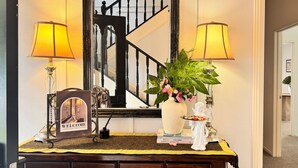 A reception desk with a welcome sign, two lamps, a vase with flowers, and a statue. - Secluded 5rooms Farmhouse – Spacious Garden, BBQ & Pet-Friendly，Edge Hamilton (Matangi)