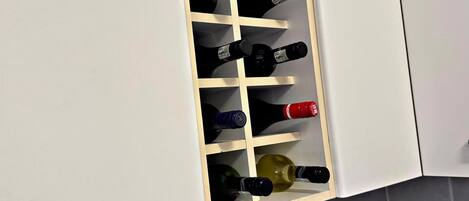 A wine rack with multiple bottles in a kitchen setting.