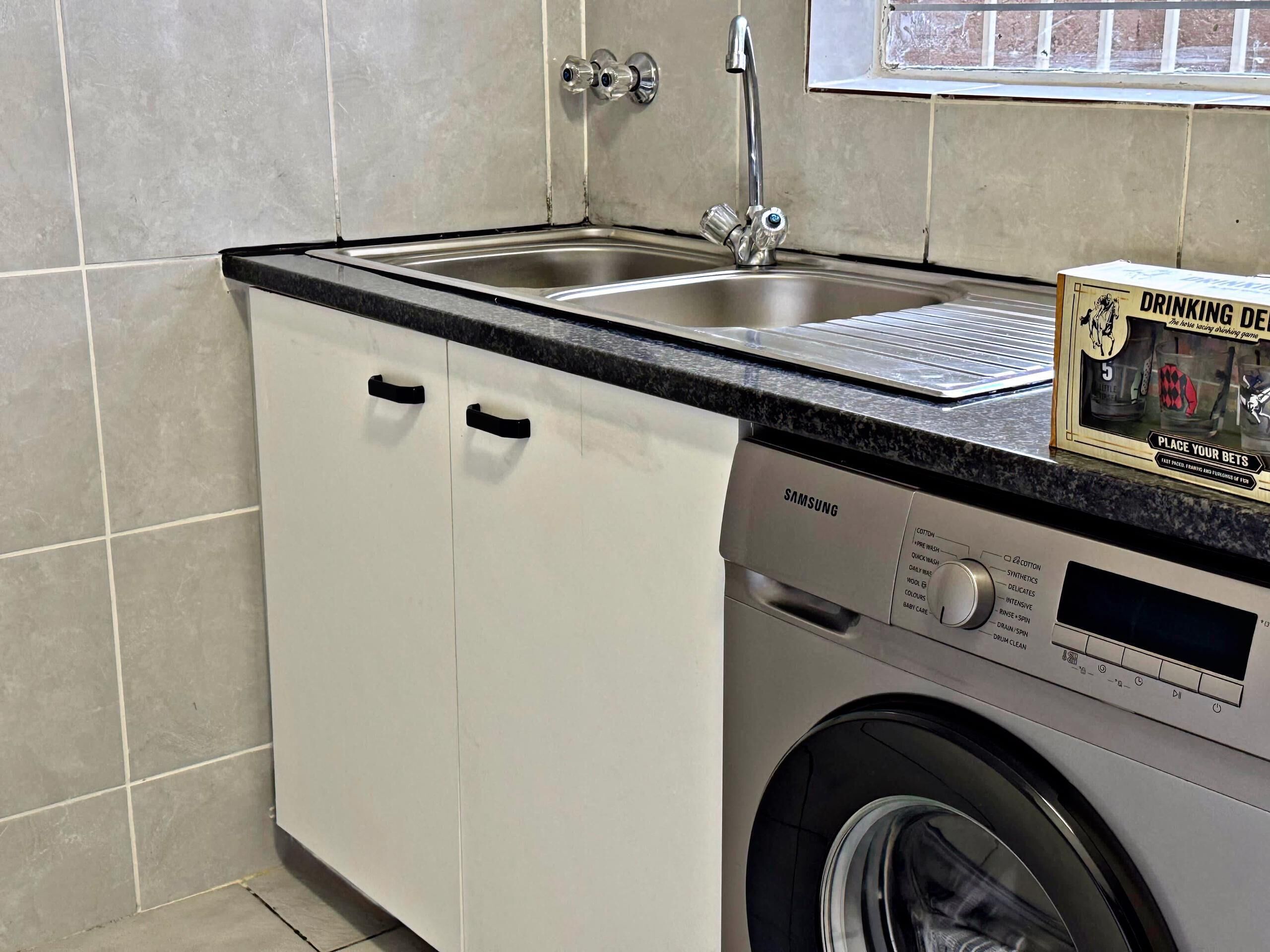 Una cocina compacta con lavavajillas integrado y un lavabo.