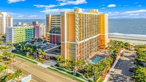 Ein Hotel mit Pool, Strandblick und mehreren Gebäuden.