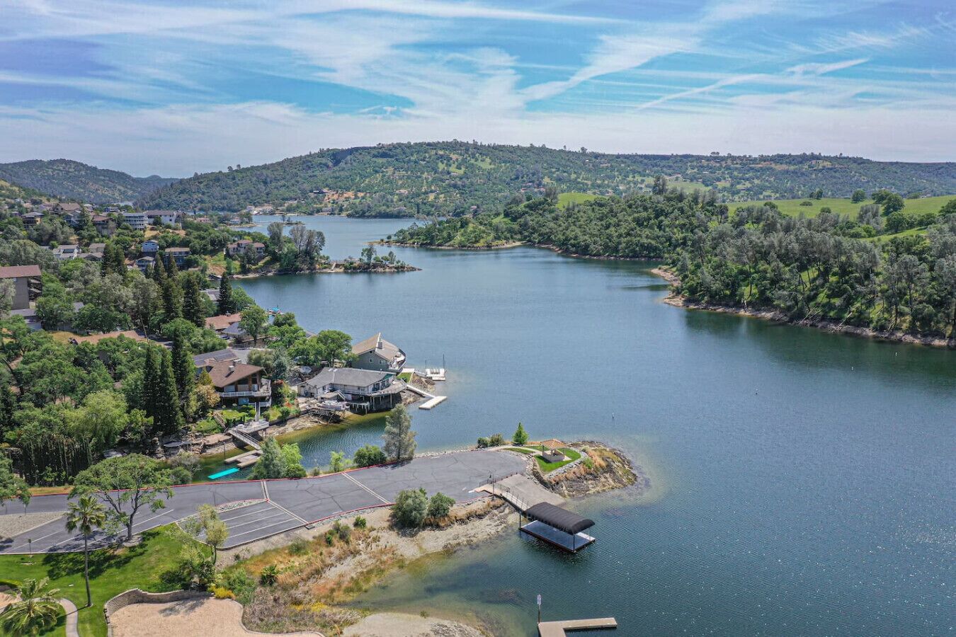 A lakeside residential area with houses, a dock, and a clear view of the lake.