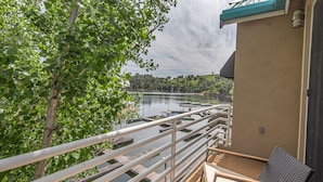 A balcony with a view of a lake, wooden deck, and a chair. - Drifters Wake & Wine Getaway (Lake Tulloch)