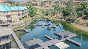 A marina with boats docked, surrounded by residential buildings and greenery. - Drifters Wake & Wine Getaway (Lake Tulloch)