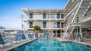 A hotel with a pool, multiple balconies, and a staircase. - Seaside Escape: Beautifully Appointed 1 BR Condo (North Wildwood)