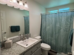 A bathroom with a sink, mirror, and toilet.