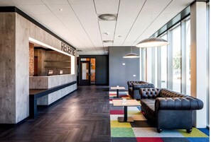 Welcome to our reception area, featuring a comfortable seating area with a sofa and rug, and a prominent reception desk.