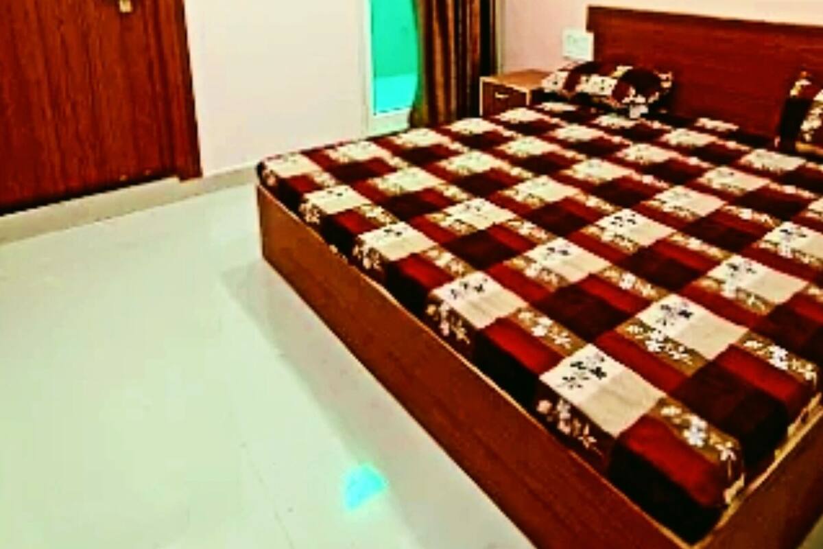 A bedroom with a wooden bed, a wooden door, and a green curtain.
