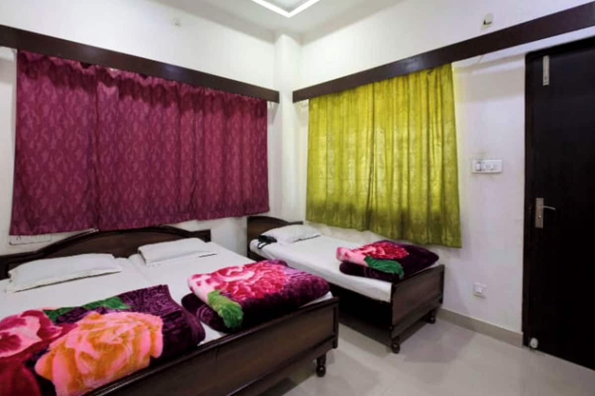 Une chambre d’hôtel avec deux lits, une armoire et une porte.