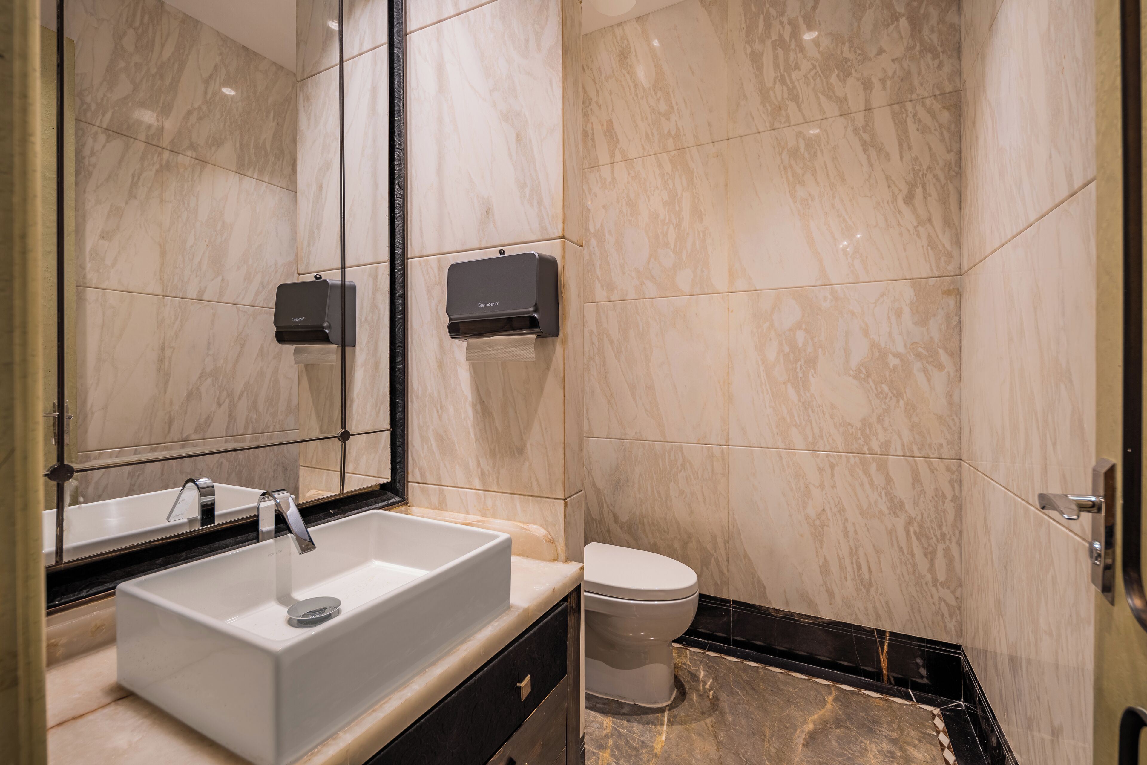 A modern bathroom with a rectangular sink, a toilet, and a mirror.