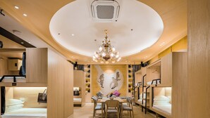 A compact, well-lit room with bunk beds, a dining table, and a chandelier. - Paris Hotel (Shanghai)