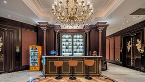 A lobby with a bar area, a vending machine, and a decorative chandelier. - Paris Hotel (Shanghai)