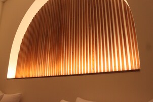 A room with a slatted ceiling design and a curved wall.