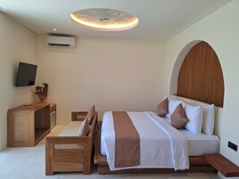 Un dormitorio con cama, televisor, cabecero de madera, aire acondicionado de pared y lámpara en el techo.