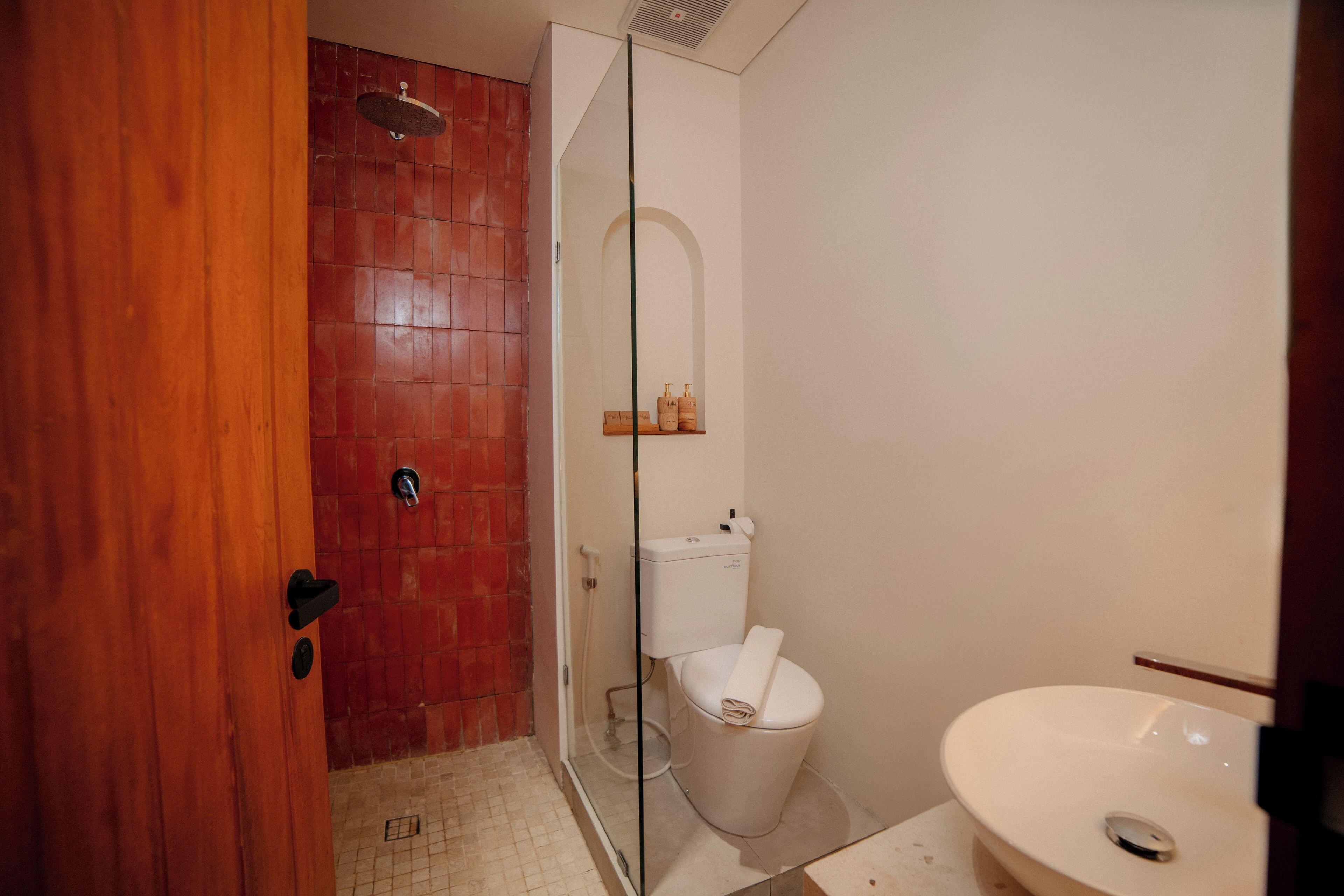 Een badkamer met een douche, toilet en wastafel.