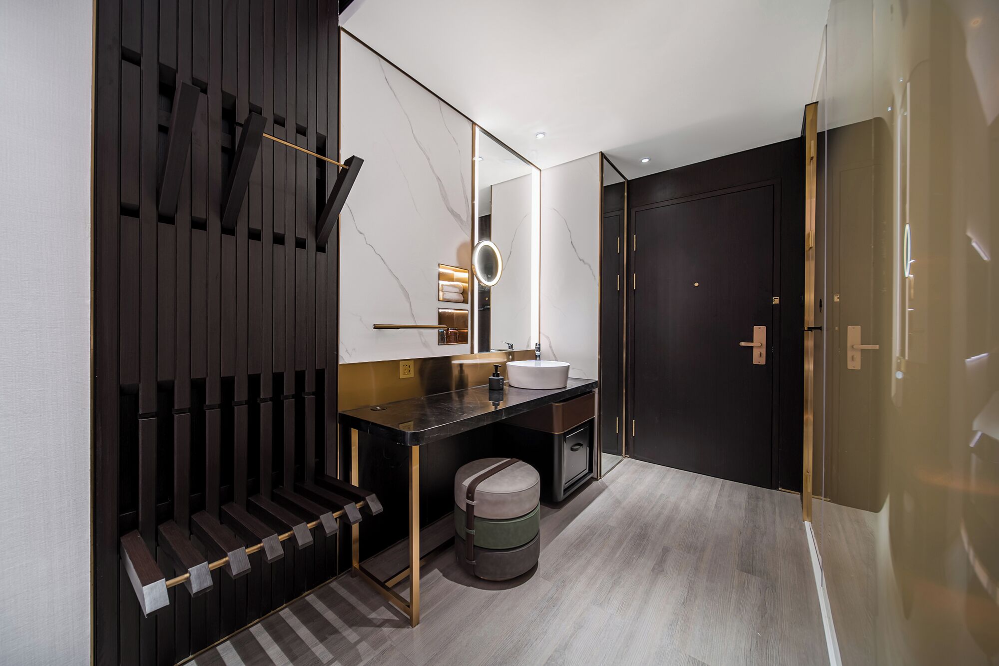 Un baño moderno con un tocador de madera oscura, un lavabo blanco y un espejo.