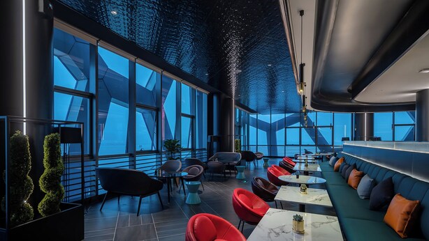 A modern interior with a long dining area, red and black chairs, and a green sofa. - CitiGO Hotel Shenzhen Shekou  (Shenzhen)