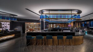 A modern bar area with a central bar, multiple stools, a ceiling light fixture, and a bar counter. - CitiGO Hotel Shenzhen Shekou  (Shenzhen)