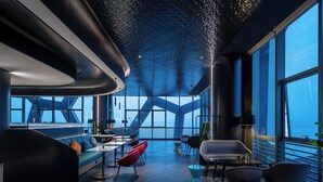 A modern interior with a curved ceiling, large windows, and contemporary furniture. - CitiGO Hotel Shenzhen Shekou  (Shenzhen)