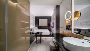A modern hotel room with a large bed, a sitting area, a vanity with a mirror, and a large bathroom sink. - CitiGO Hotel Shenzhen Shekou  (Shenzhen)