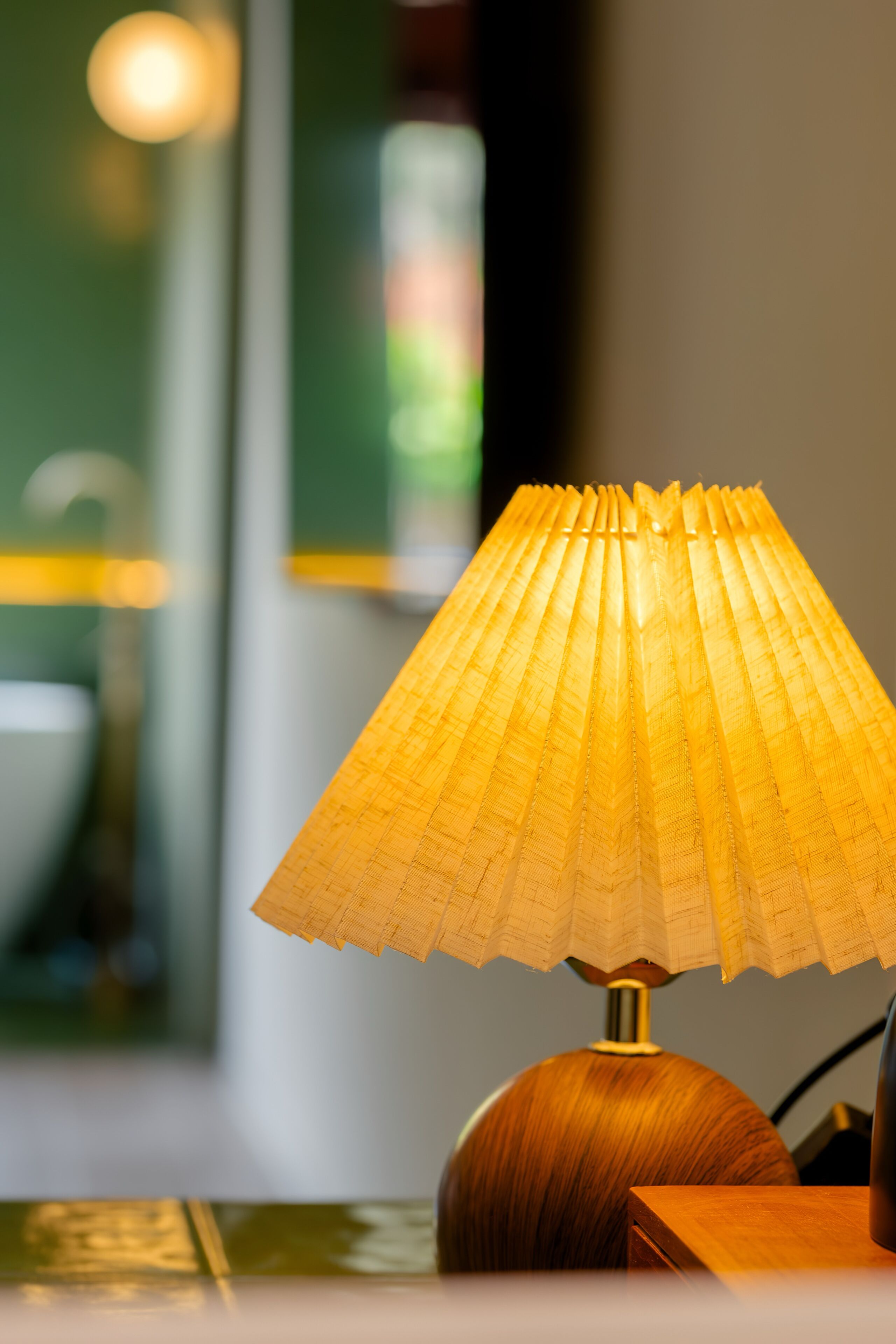 A lamp with a pleated shade on a wooden table.
