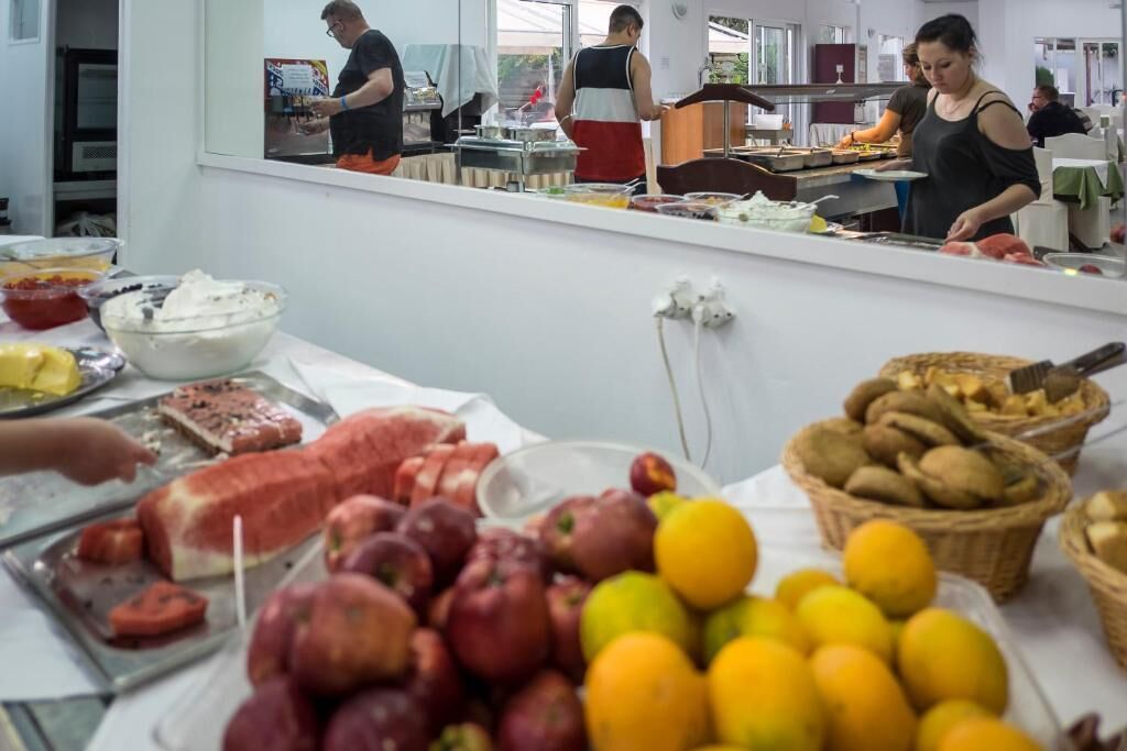 Un bufé con diversas opciones de comida, incluyendo frutas, carnes y productos horneados.