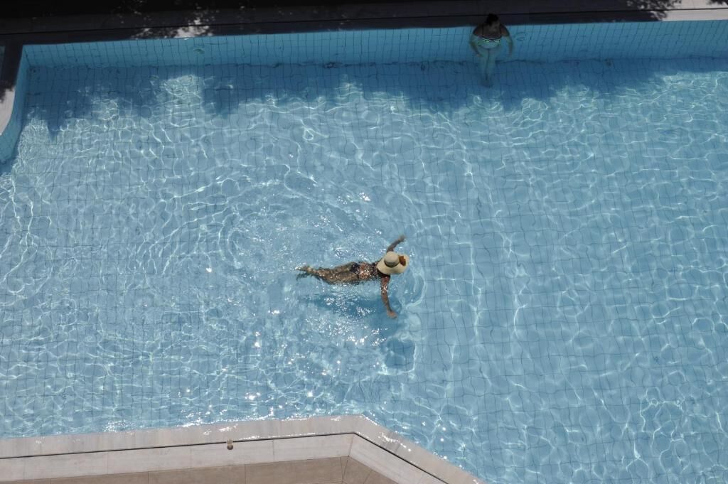 A swimming pool with clear water and a person swimming.