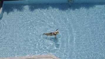 A swimming pool with clear water and a person swimming.