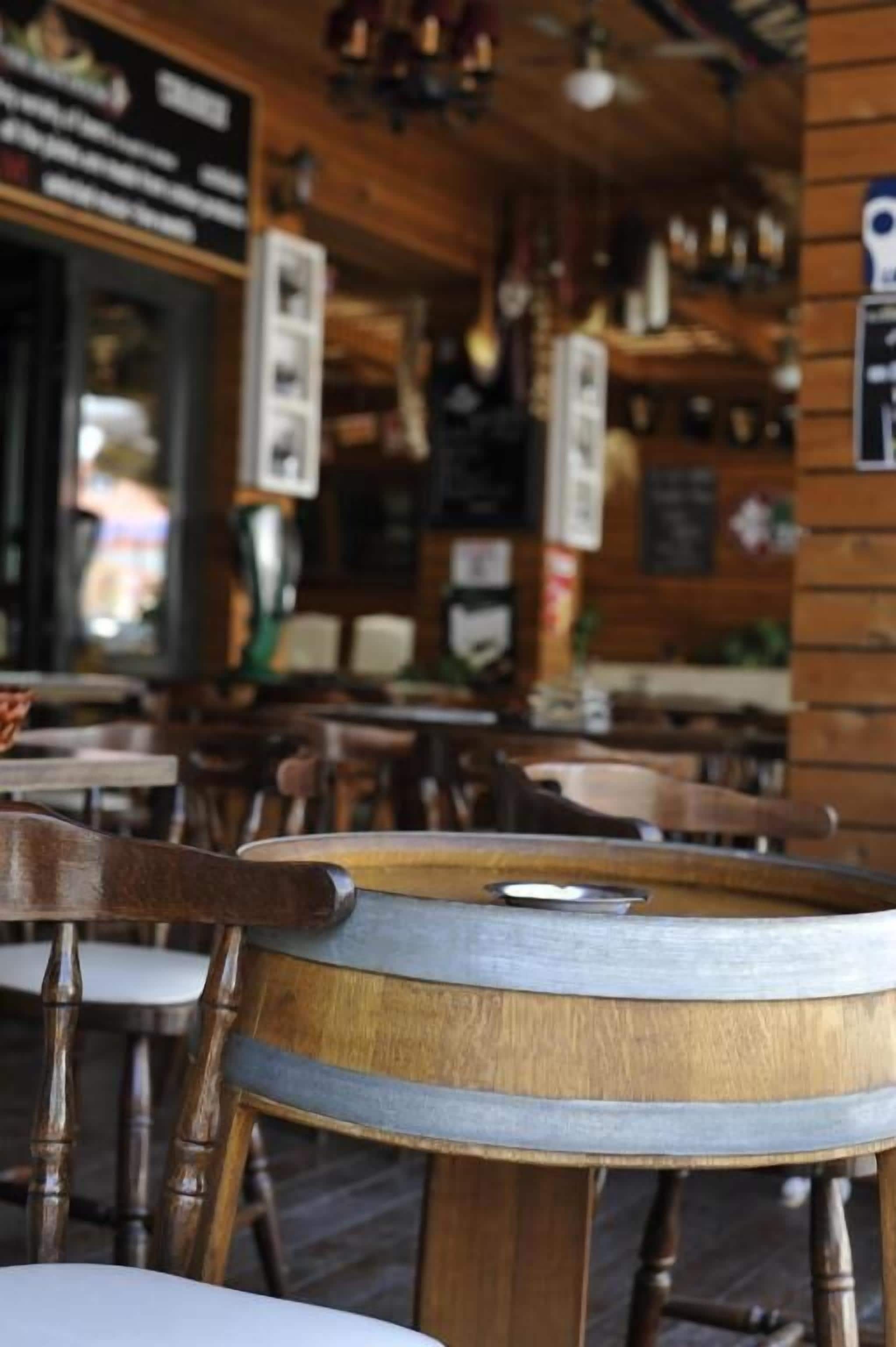 Un intérieur en bois avec des tables et des chaises, un coin bar et des luminaires suspendus.