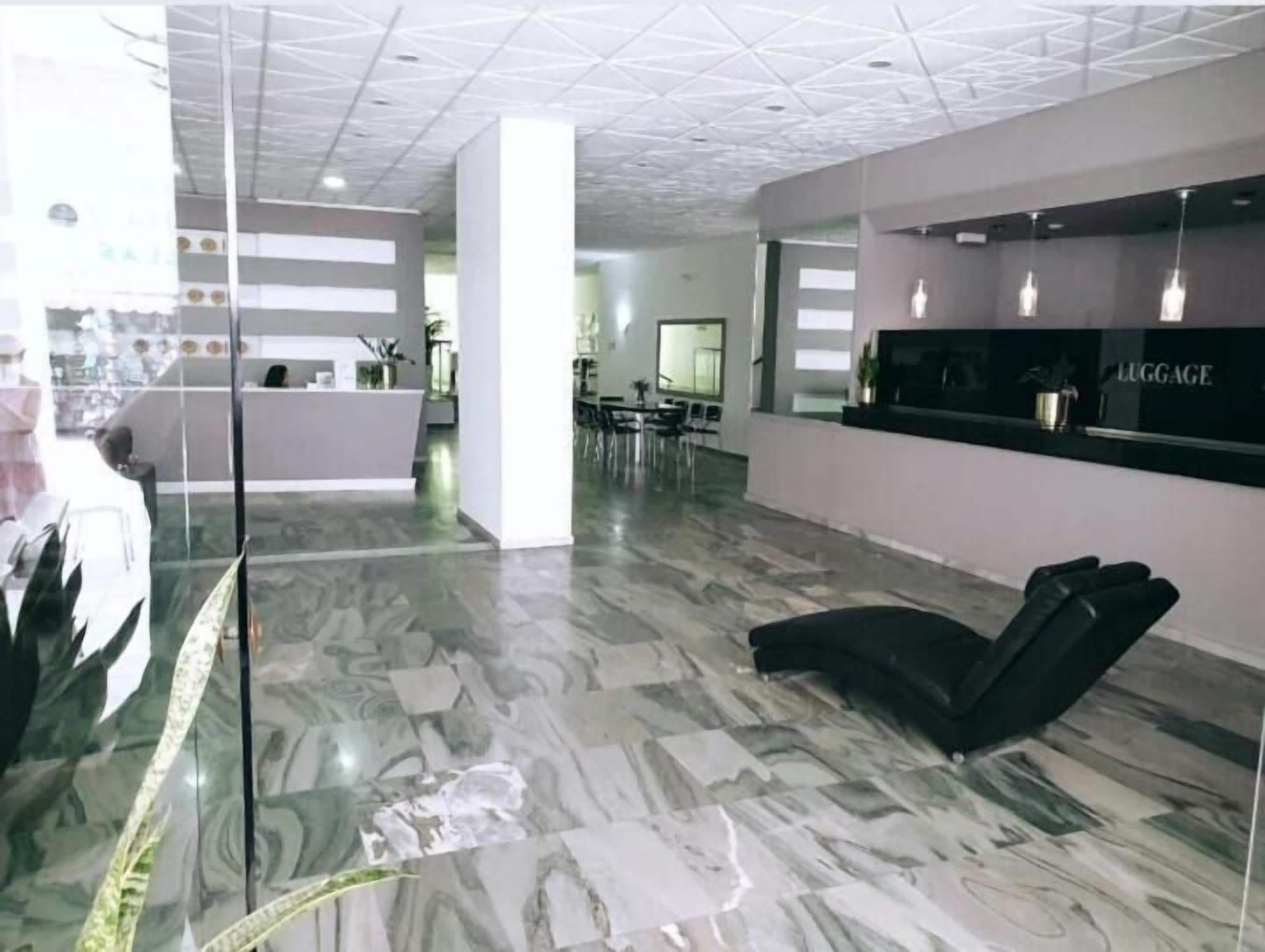 Un espace d’accueil doté d’un comptoir, de sièges et d’un aménagement intérieur moderne.
