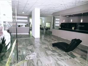 Ett receptionsområde med en disk, sittplatser och en modern inredning.