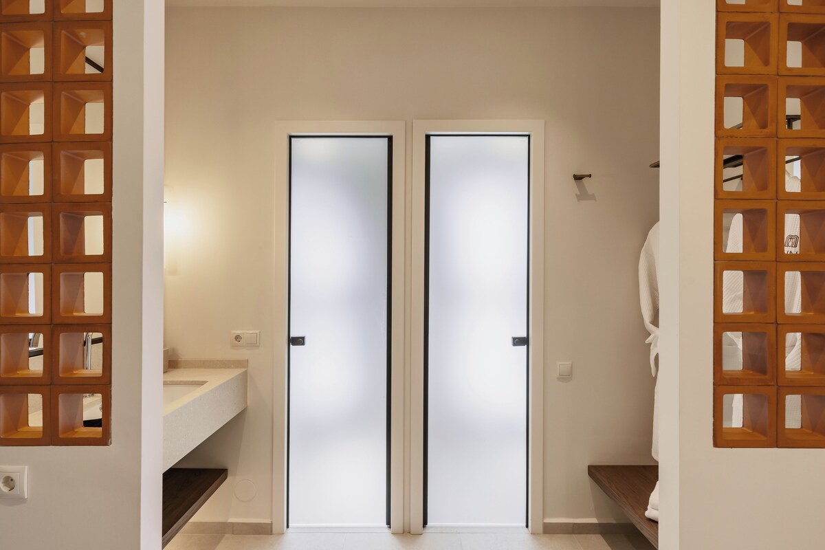 A bathroom with a double door, a sink, and a towel rack.