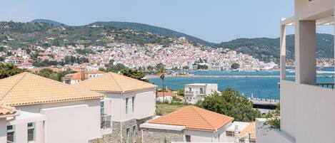 Une ville côtière aux bâtiments blancs, offrant une vue sur la mer et s’étendant sur des collines.