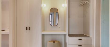 Une salle de bain moderne avec un grand miroir, un meuble-lavabo et un espace douche.