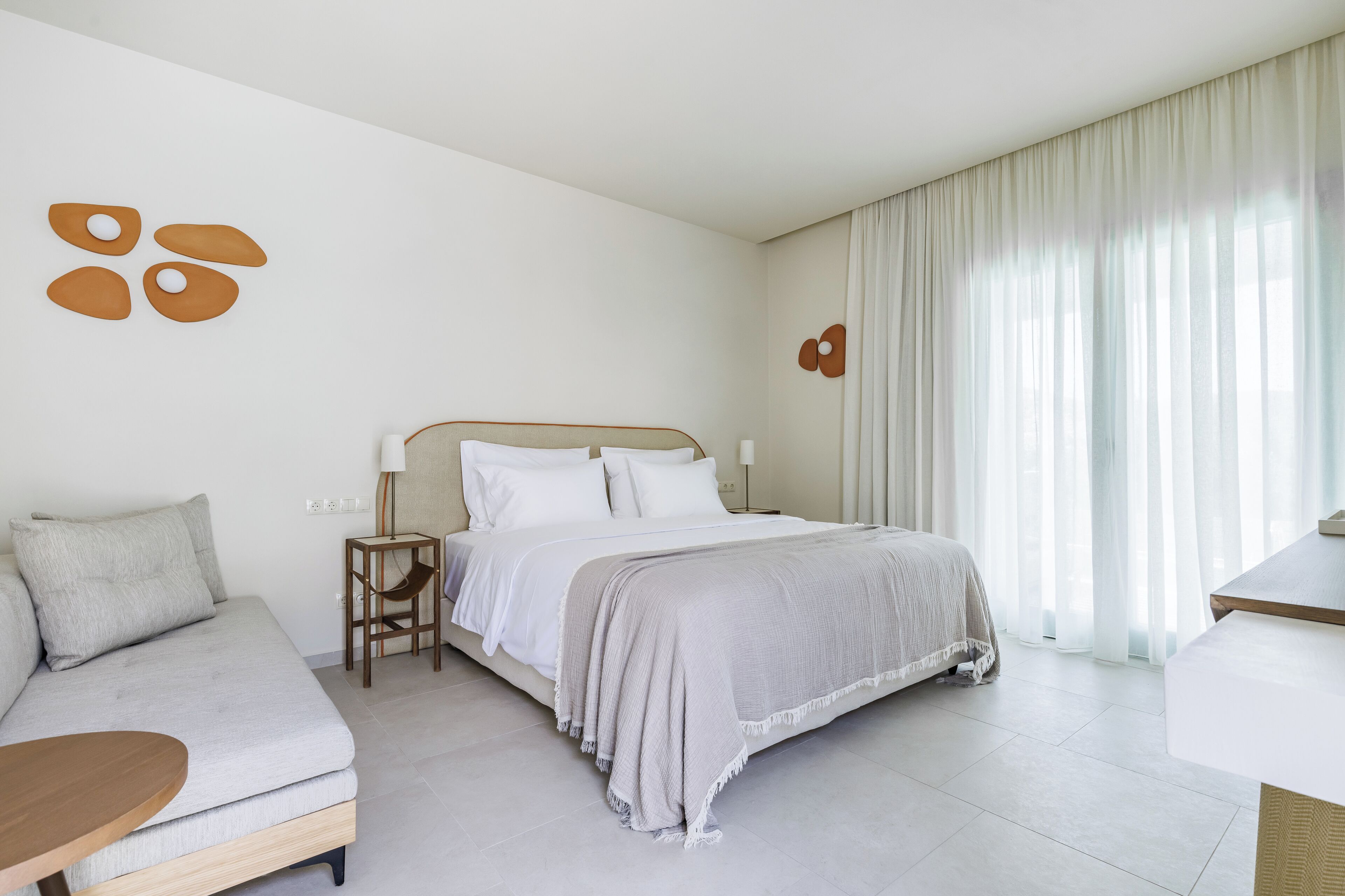 Une chambre d’hôtel moderne avec un lit, un canapé et une petite table.