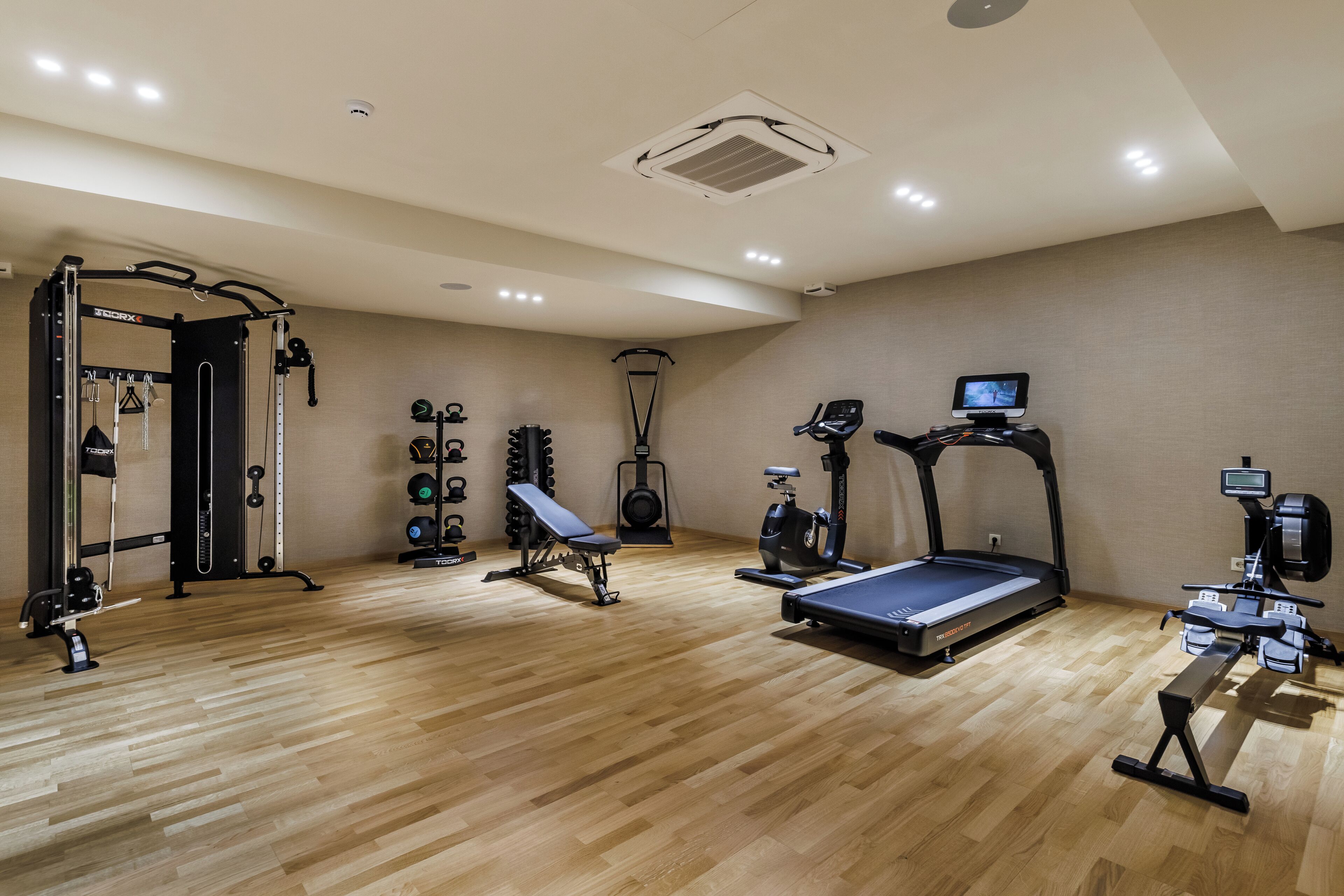 A gym with a pull-up bar, weight bench, elliptical, stationary bike, and treadmill.