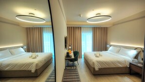 A hotel room with two beds, a desk, and a mirror. - Aste Hotel (St. Julian's)