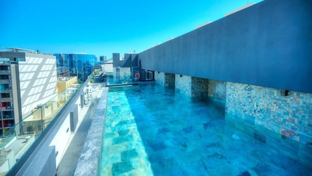 A rooftop pool with a clear view of the city skyline, surrounded by modern buildings. - Aste Hotel (St. Julian's)